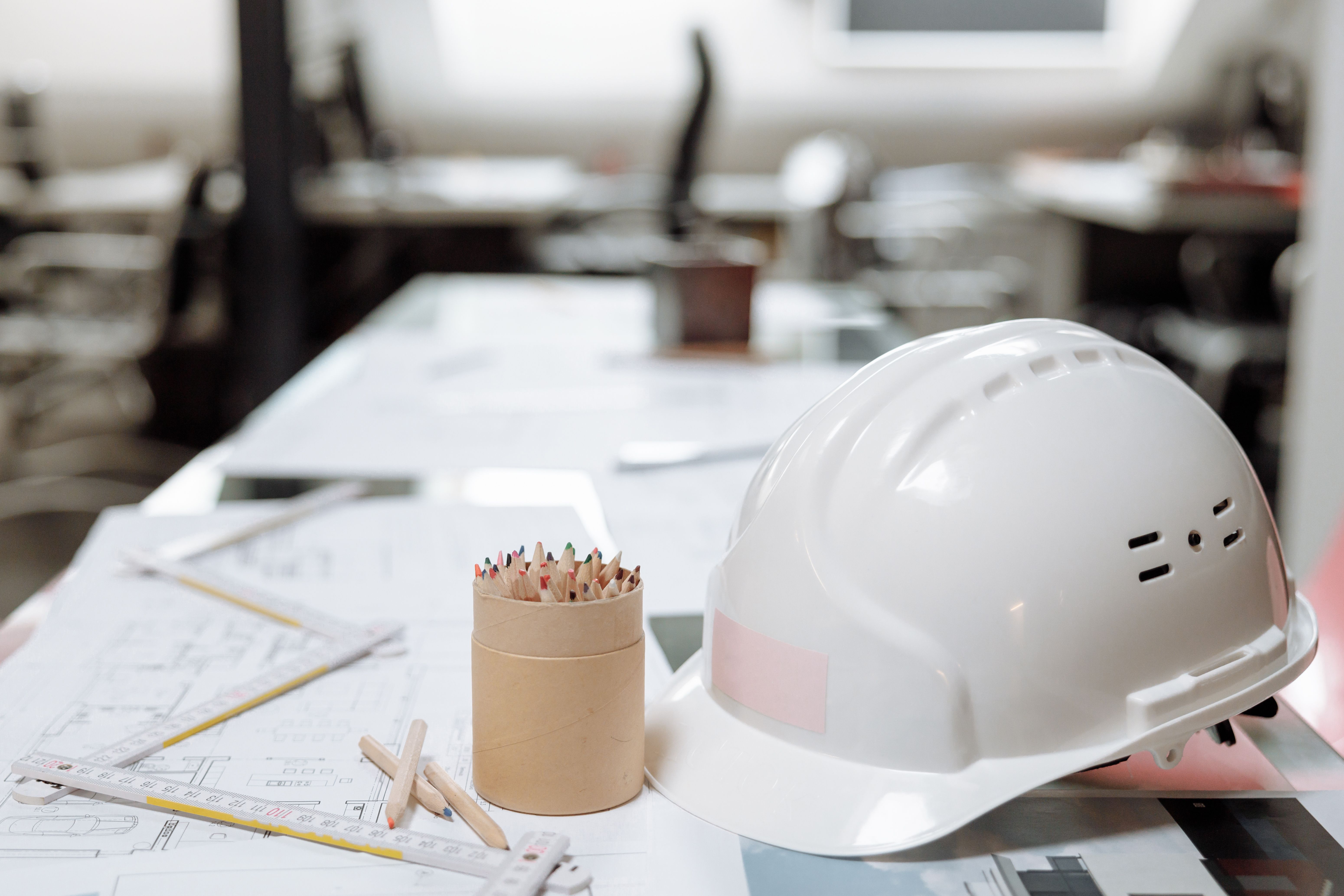 White hard hat resting on architectural blueprints