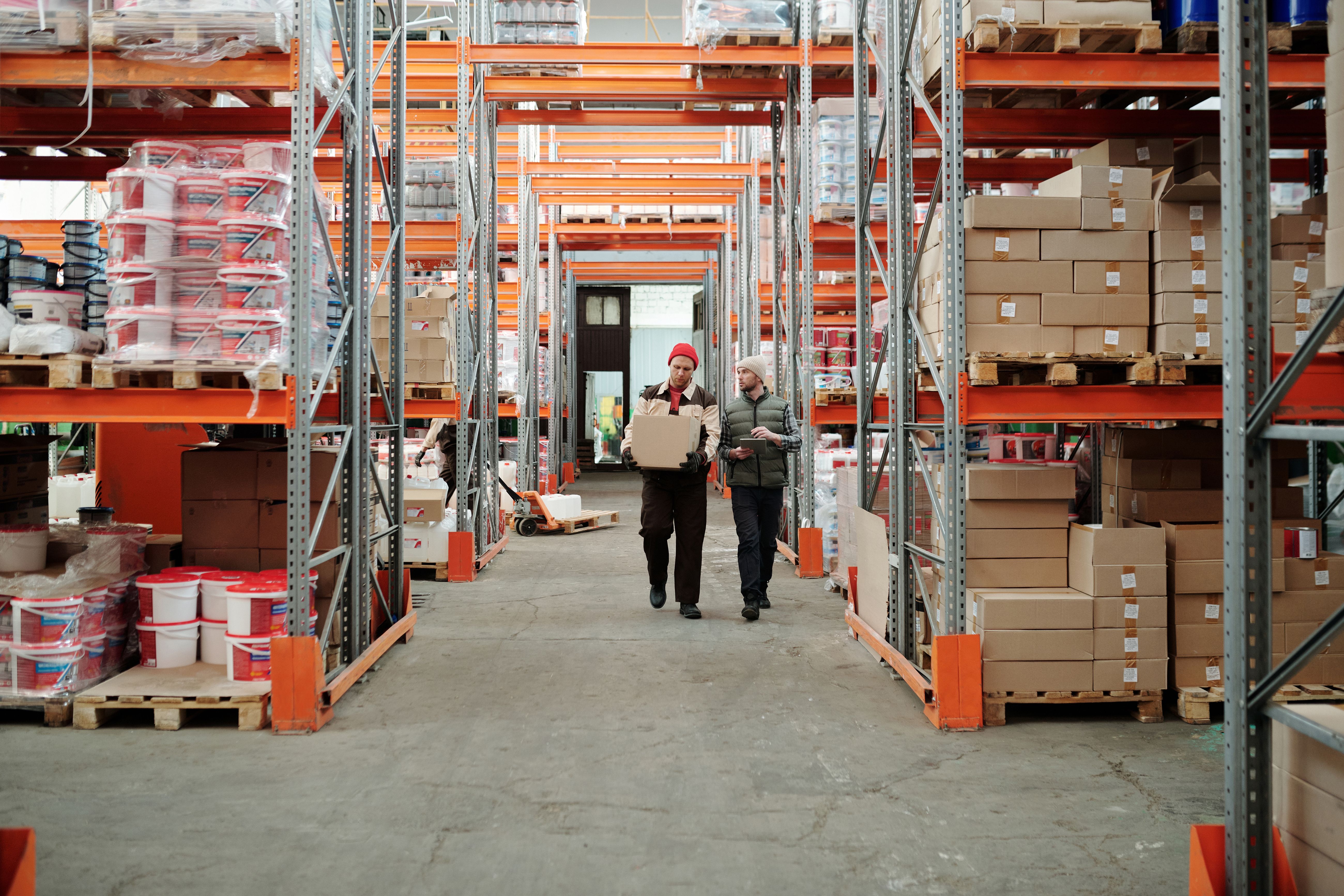 Workers moving inventory inside a logistics warehouse